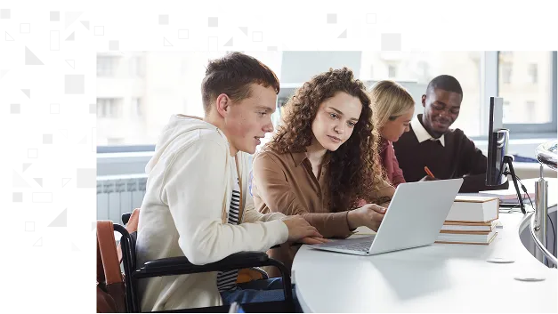 studenti seduti insieme ad un tavolo di fronte ad un laptop