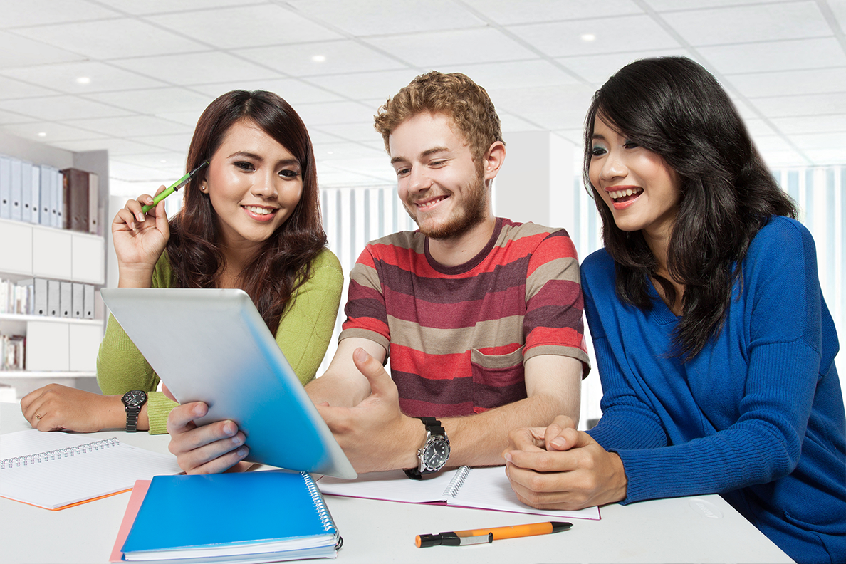 tre studenti che sorridono mentre studiano insieme usando un tablet e i loro appunti